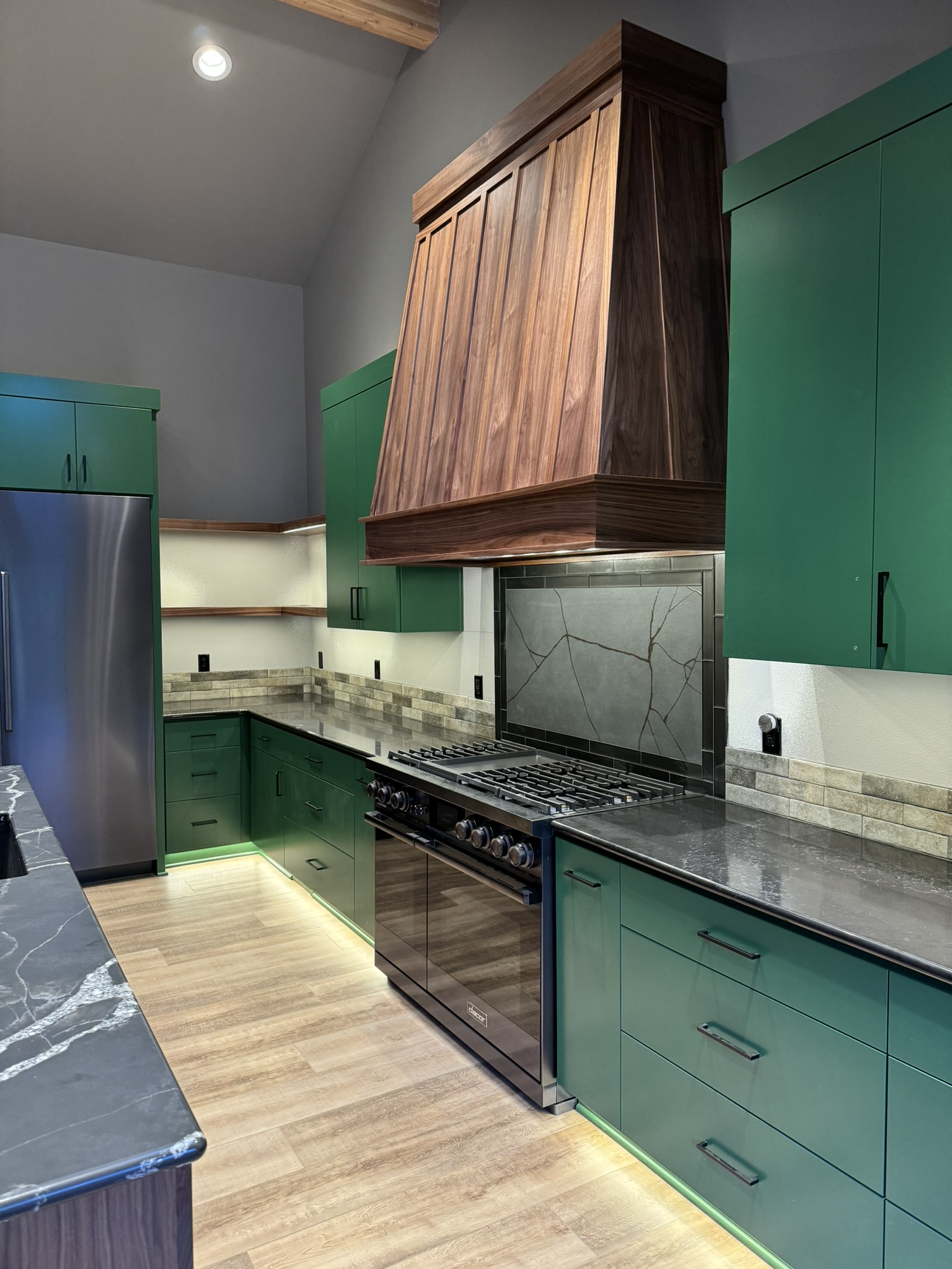 Custom island in walnut kitchen with dark stone counters and integrated seating