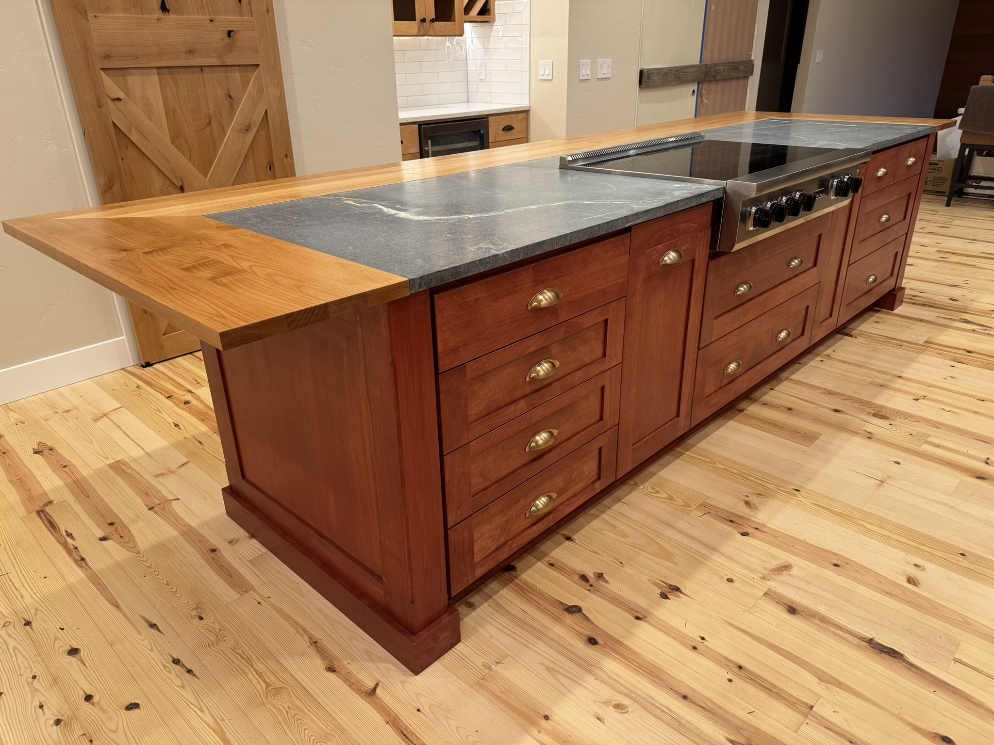 Detail of soapstone countertop and custom wood cabinetry with integrated appliances