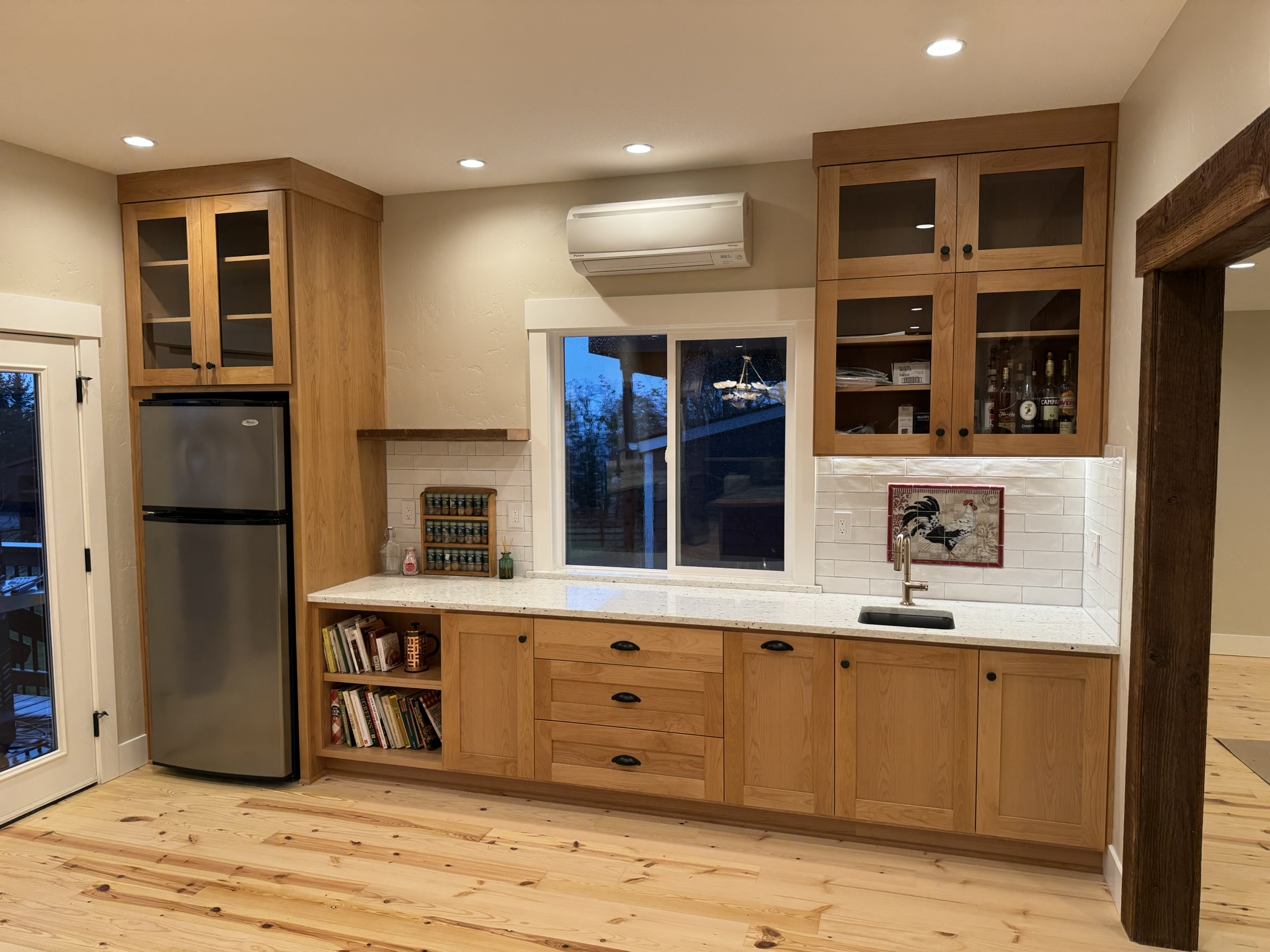 Wall cabinet run with upper glass-front doors and warm stained lower cabinets