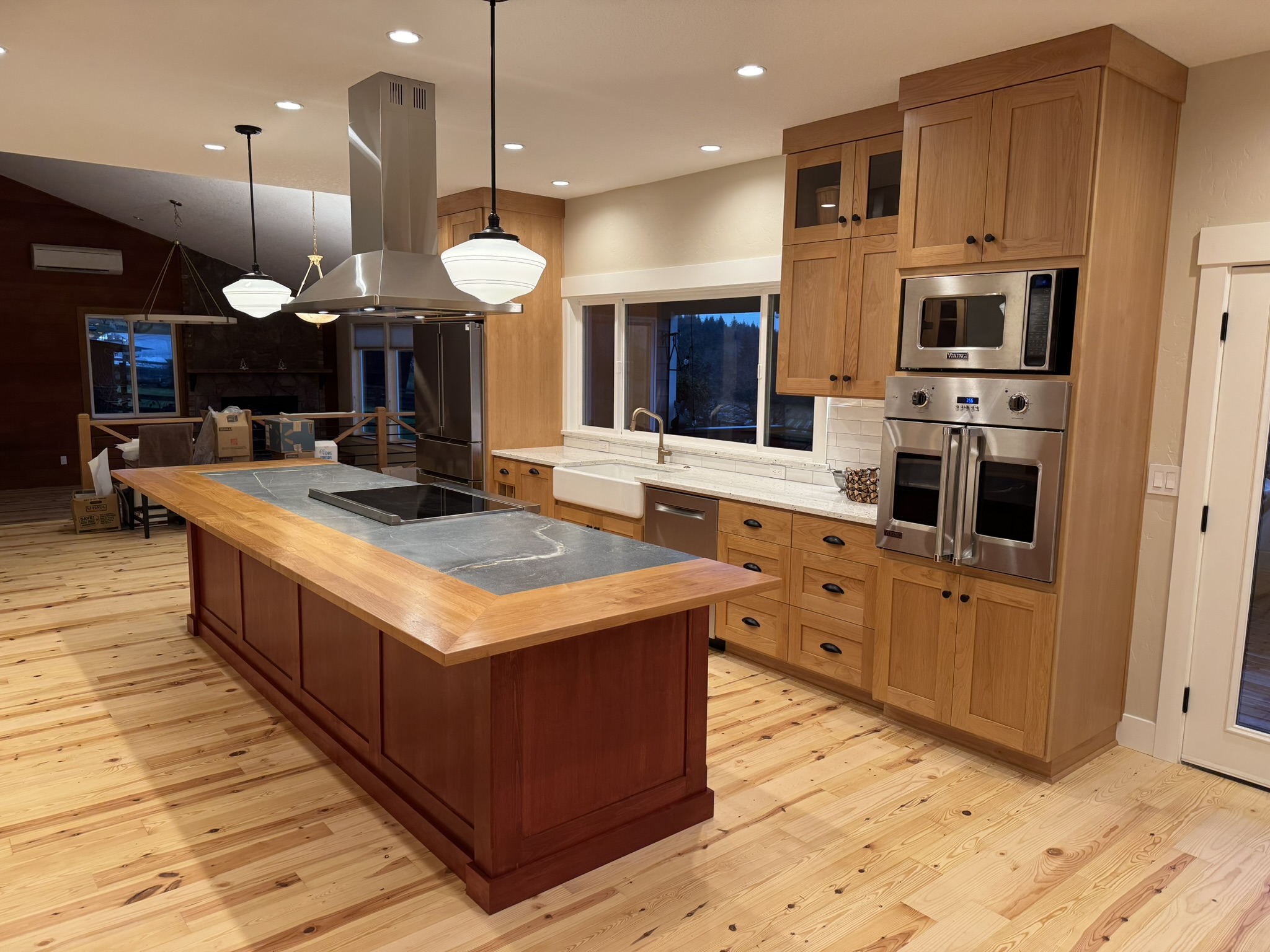 Kitchen overview showing warm wood cabinetry, soapstone counters, and natural light
