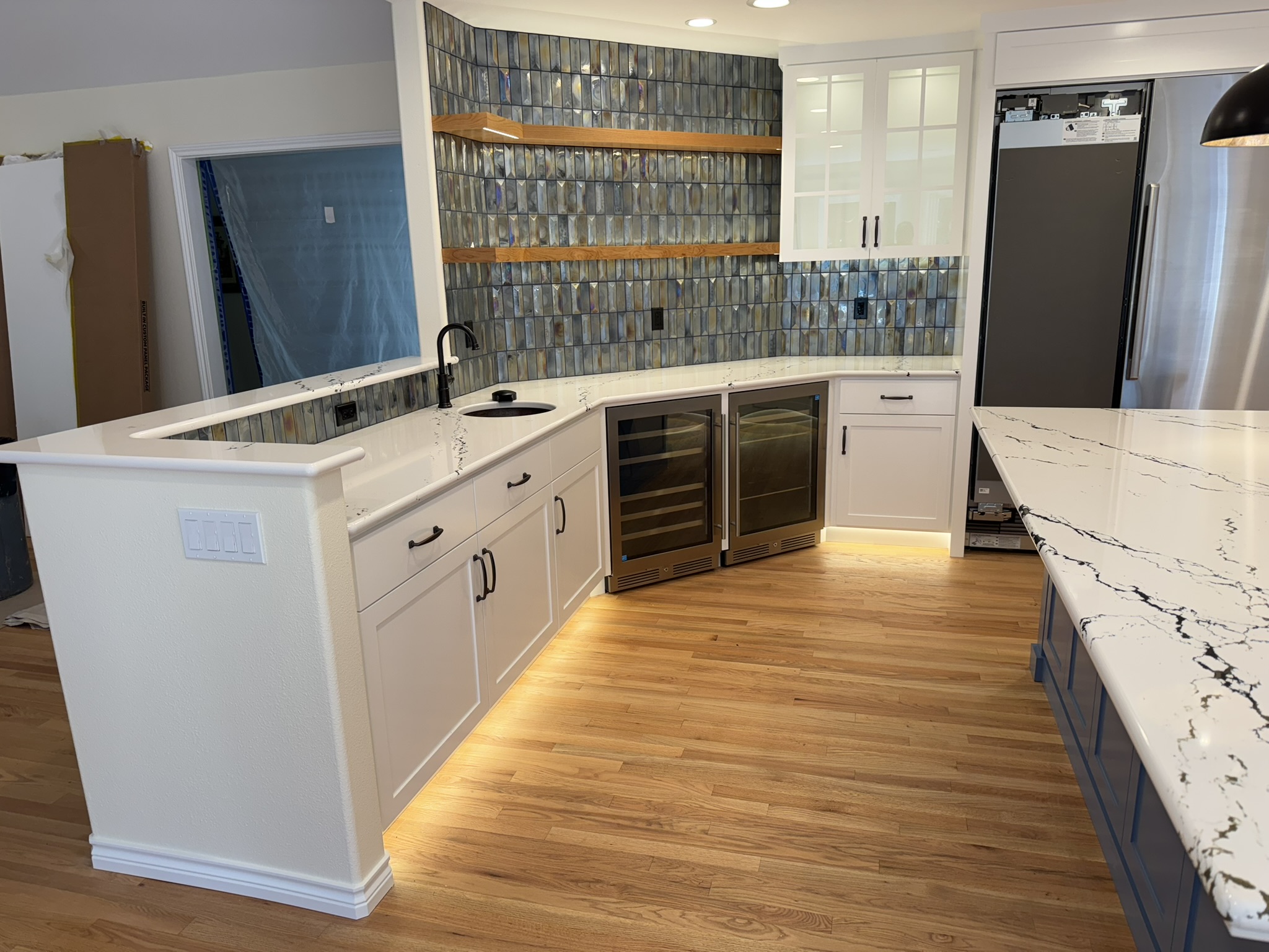 Blue island detail showing book-matched cabinetry and integrated seating