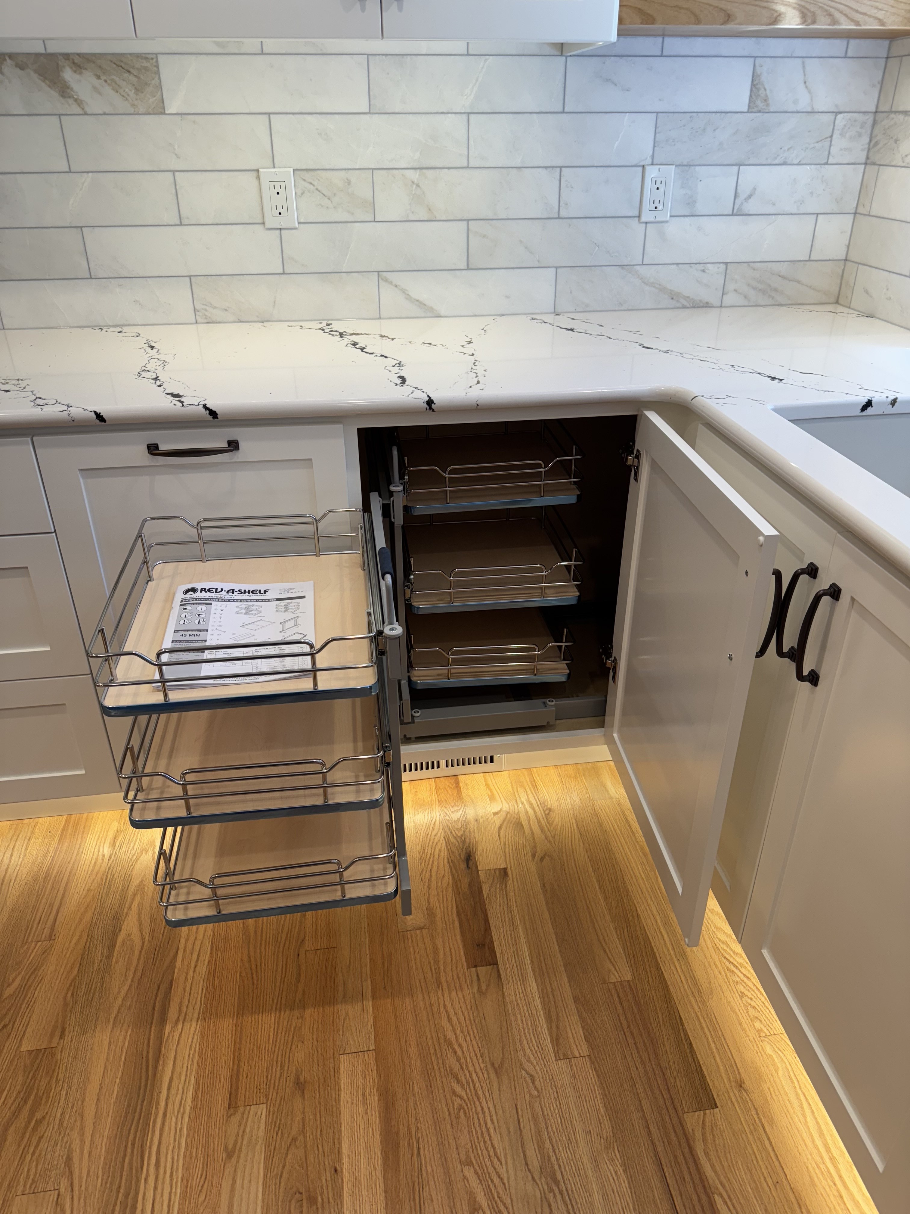 Fully extended blind-corner cabinet organizer with front baskets pulled out and rear shelves visible, showing full access to corner space