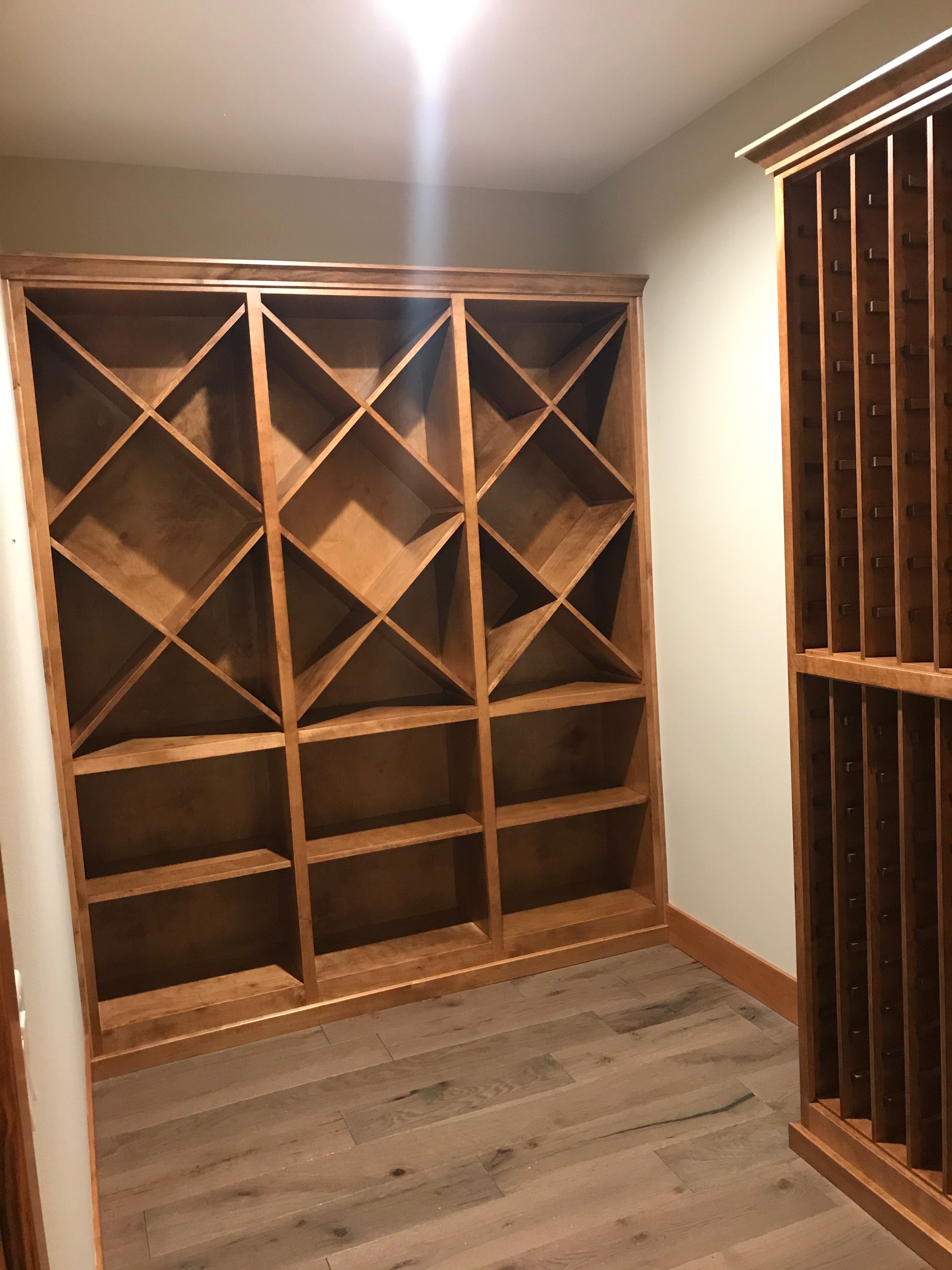 Wine cellar detail showing individual bottle slots, display case, and warm wood finish