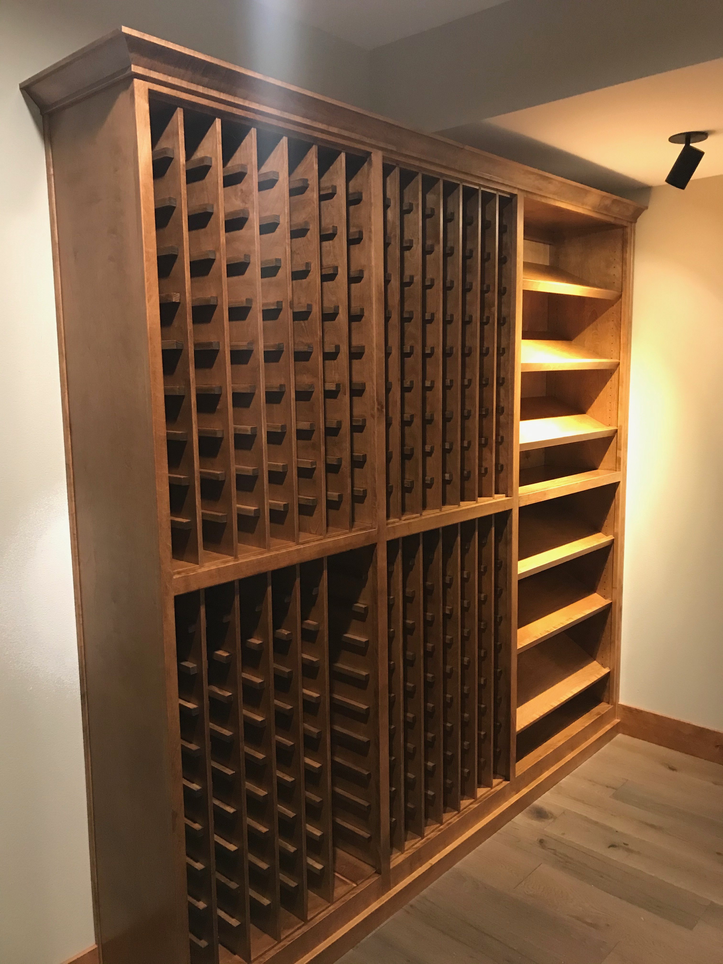 Custom built wine cellar with floor-to-ceiling wood racking, display shelves, and atmospheric lighting