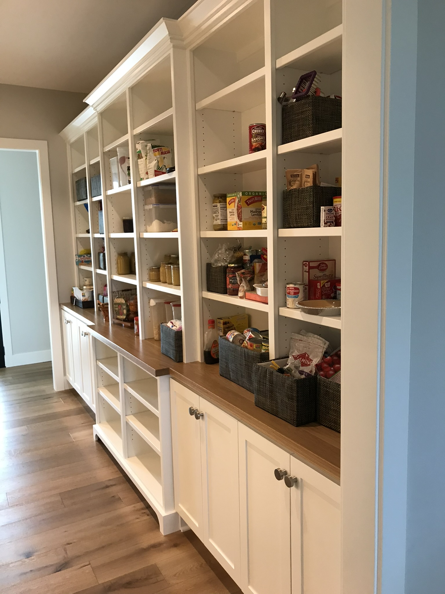 Pantry cabinet detail showing adjustable shelves, labeled bins, and custom drawer organization