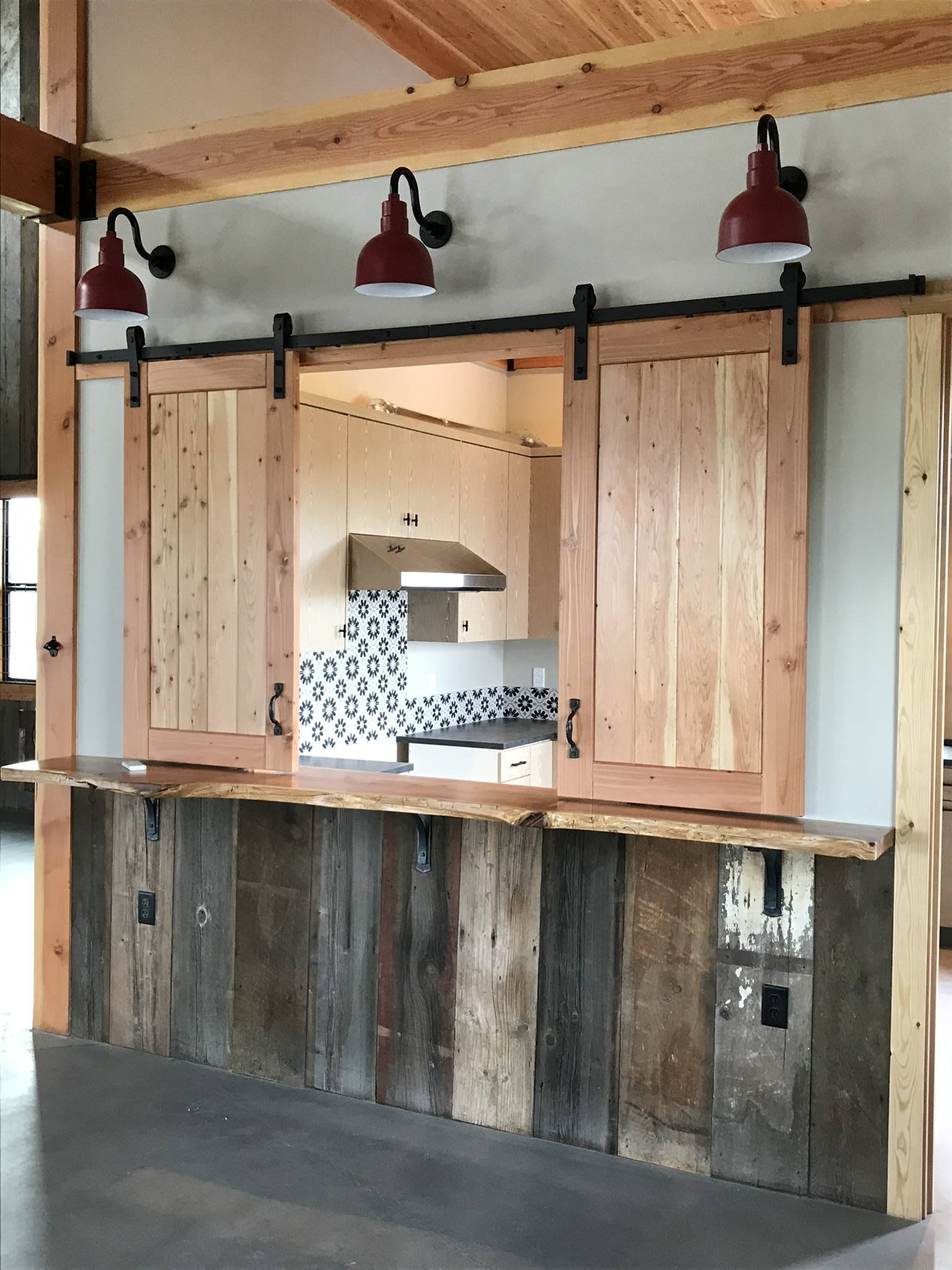 Custom rustic barn door pass-through with handcrafted millwork detail and sliding hardware