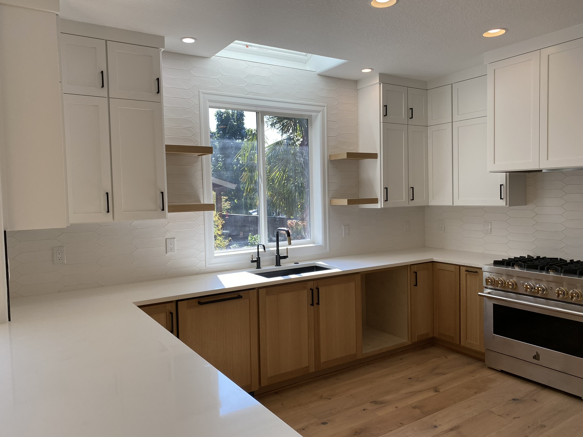 Natural oak island detail showing book-matched grain and white quartz countertops