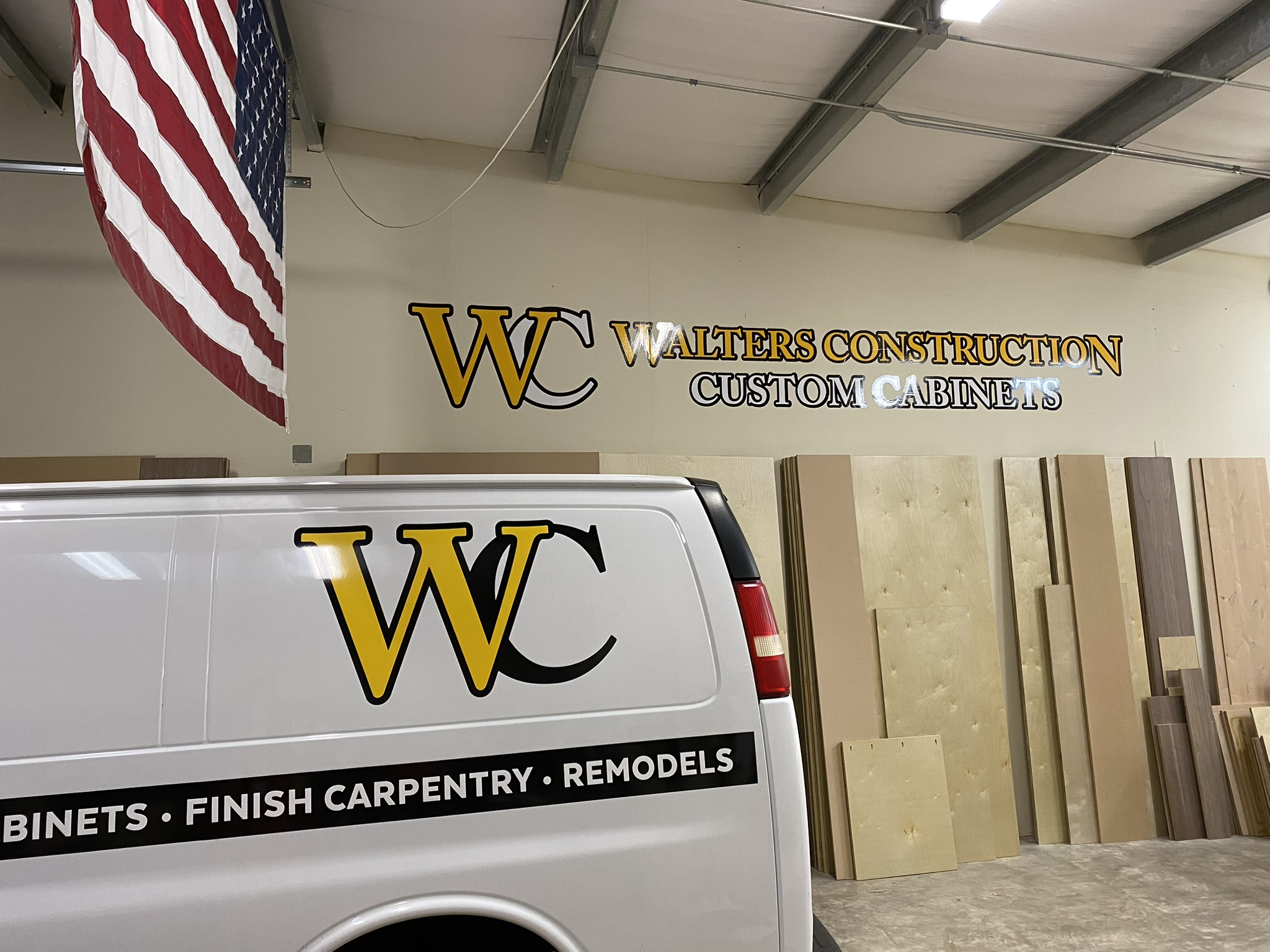 Walters Construction Custom Cabinets shop interior with branded van and company signage