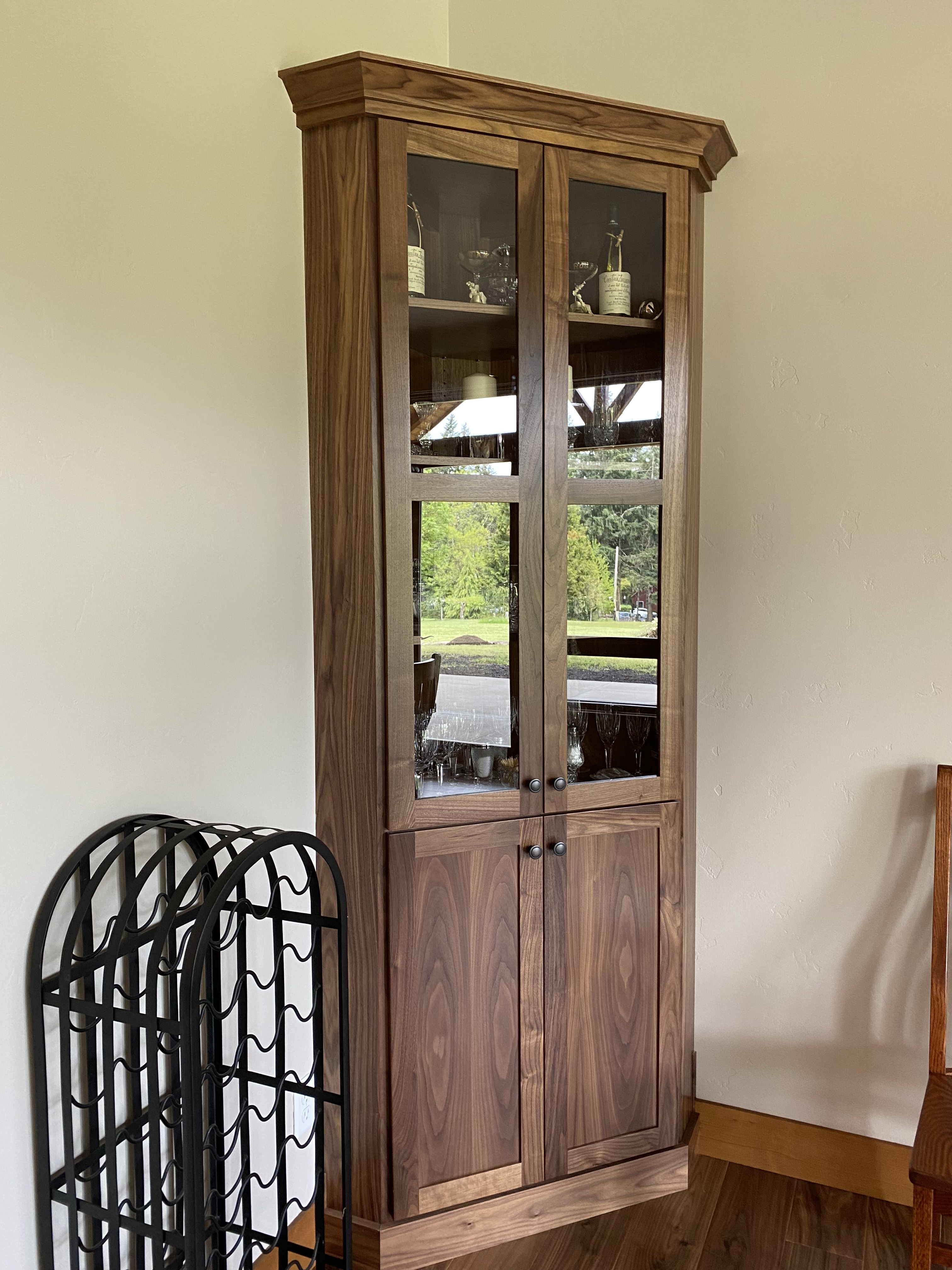 Custom walnut display cabinet with glass-front doors and paneled lower doors