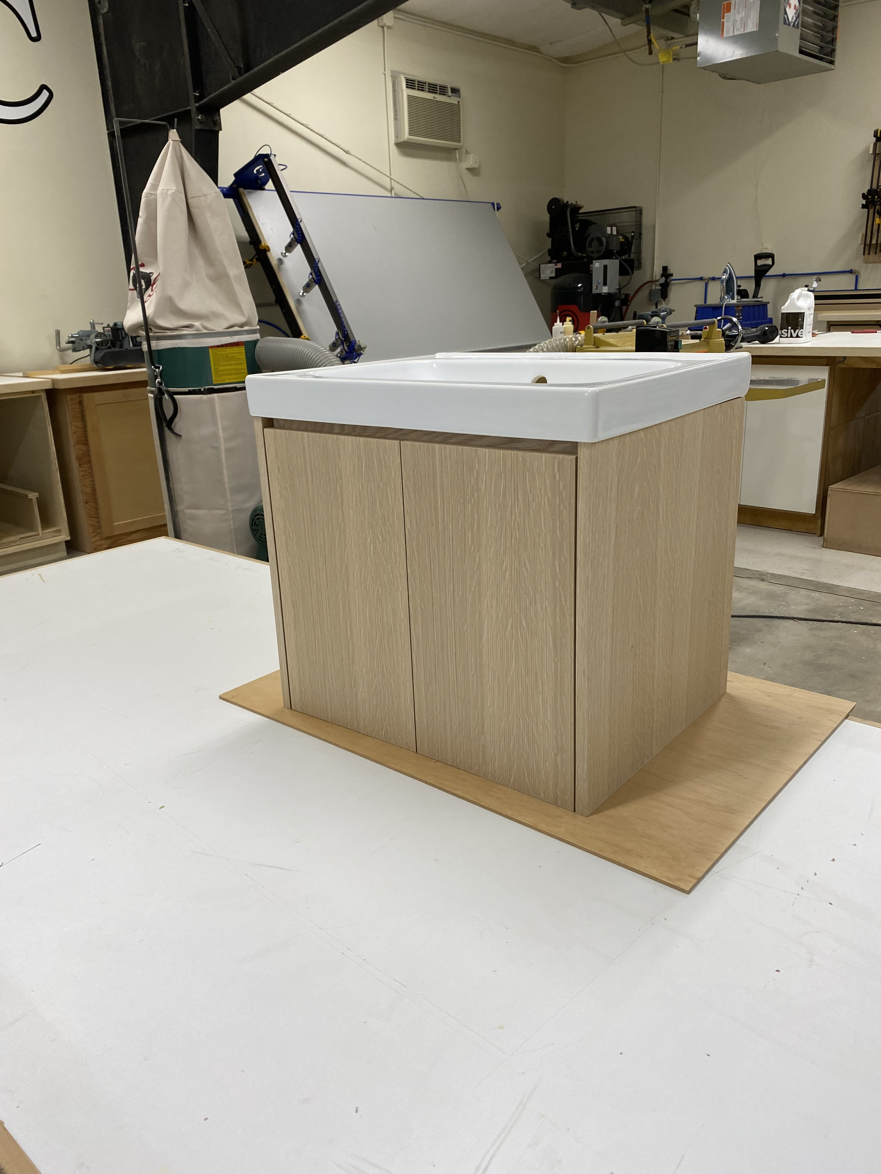 Light wood grain floating single vanity with white vessel sink, fresh from the shop