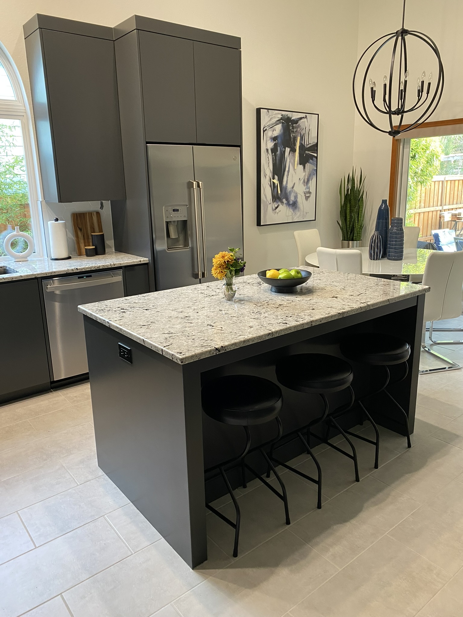 Lifestyle view of charcoal kitchen showing open layout and dark stone countertops