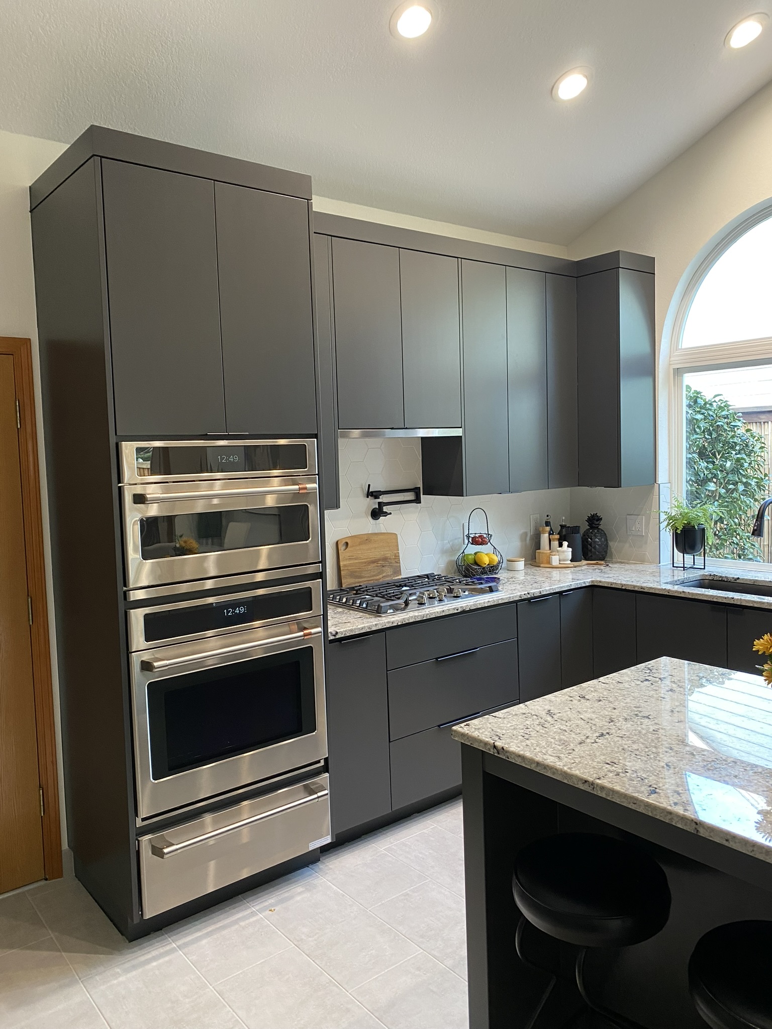 Range and hood detail with charcoal slab cabinetry and precise panel alignment