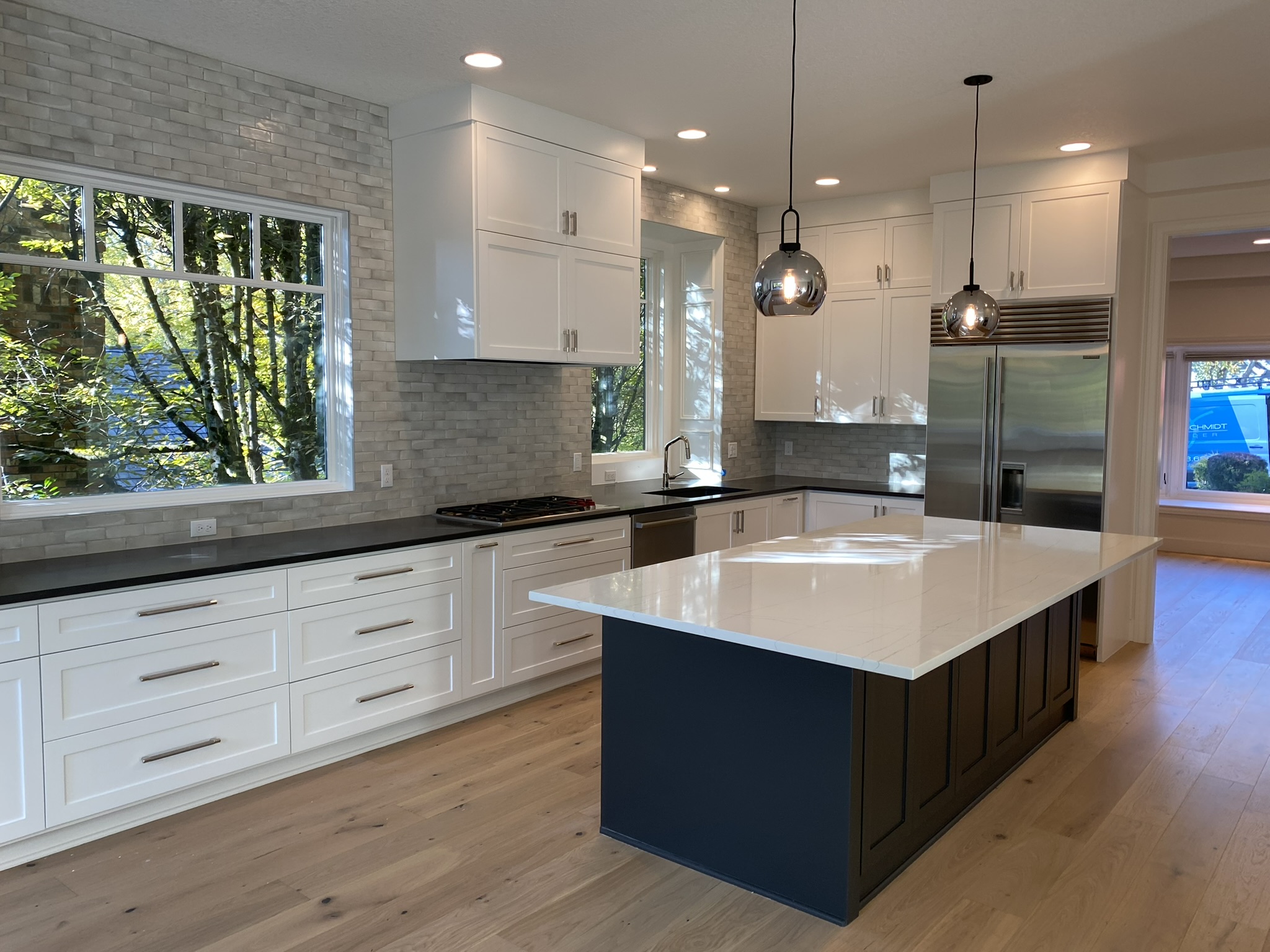 Custom refrigerator surround with white cabinetry and built-in panel fridge